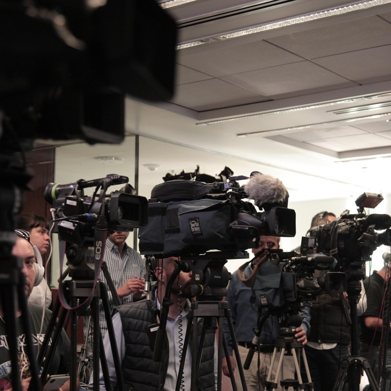 Several TV cameras set up at a press conference
